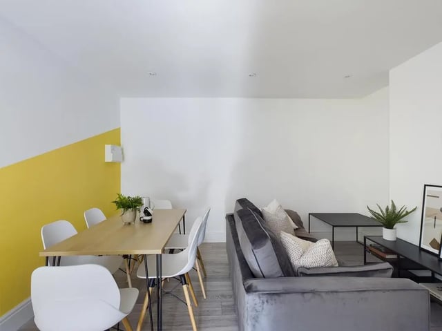Dining table with chairs and grey sofa living room at 6 Bedroom House at 47, Monks Road in Lincoln Student Accommodation