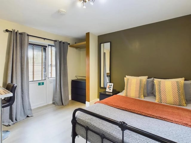 Bed with pillows curtains door desk and dresser bedroom at 7 Bedroom House at 19, Studios at, St. Catherines in Lincoln Student Accommodation