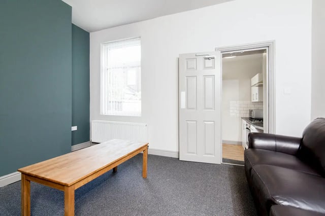 Wooden table dark sofa kitchen visible living room at 3 Bedroom House at 8, Haddon Street in Salford Student Accommodation