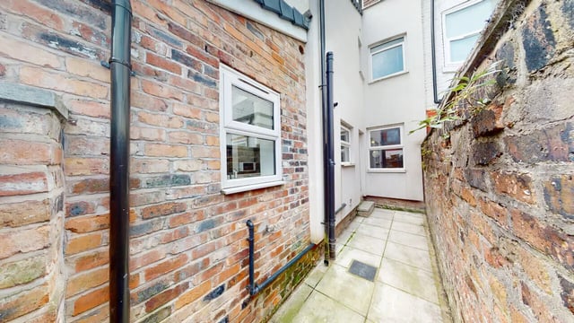 Brick building side with tiled patio exterior at 6 Bedroom House at 18, Halsbury Road in Liverpool Student Accommodation