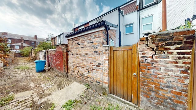 Brick wall with gate and blue bin exterior at 6 Bedroom House at 18, Halsbury Road in Liverpool Student Accommodation