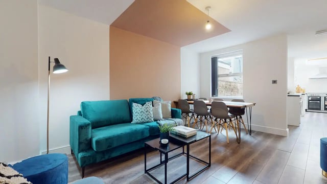 Teal sofa coffee tables dining table living room at 6 Bedroom House at 18, Halsbury Road in Liverpool Student Accommodation