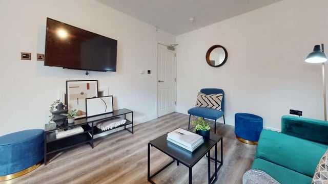 Modern living room with tv and blue furniture living room at 6 Bedroom House at 18, Halsbury Road in Liverpool Student Accommodation