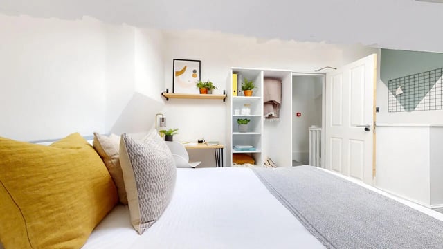 Bed with yellow and grey pillows study desk shelf bedroom at 6 Bedroom House at 18, Halsbury Road in Liverpool Student Accommodation