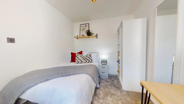 Bed with pillows nightstand and bookshelf bedroom at 6 Bedroom House at 18, Halsbury Road in Liverpool Student Accommodation
