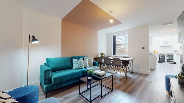 Sofa dining table and kitchen living room at 6 Bedroom House at 18, Halsbury Road in Liverpool Student Accommodation