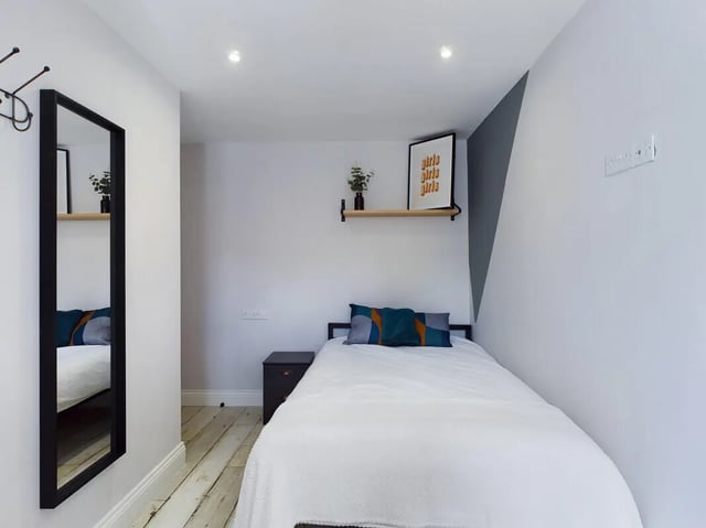 Bed with pillows side table mirror bedroom at 7 Bedroom House at 4, Well Meadow Drive in Sheffield Student Accommodation