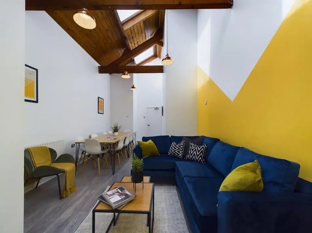 Blue sectional couch dining table and chairs living room at 9 Bedroom House at 19A, Bower Road in Sheffield Student Accommodation