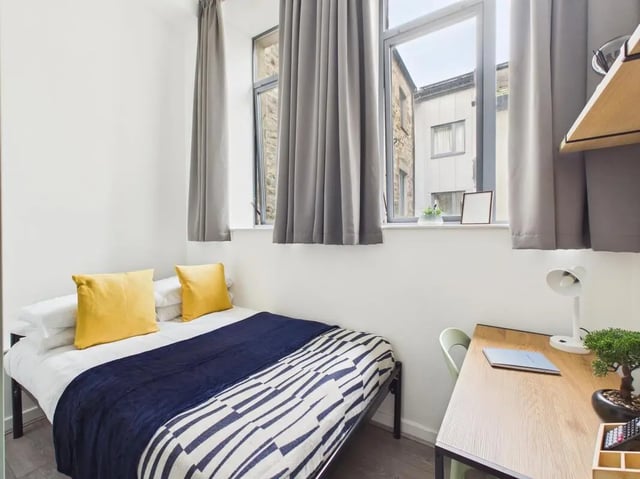 Bed with yellow pillows and desk bedroom at 3 Bedroom House at Flat 3, 18, China Street in Lancaster Student Accommodation