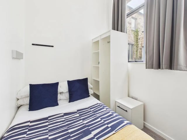 Bed with navy pillows white bedding white wardrobe and nightstand bedroom at 3 Bedroom House at Flat 3, 18, China Street in Lancaster Student Accommodation
