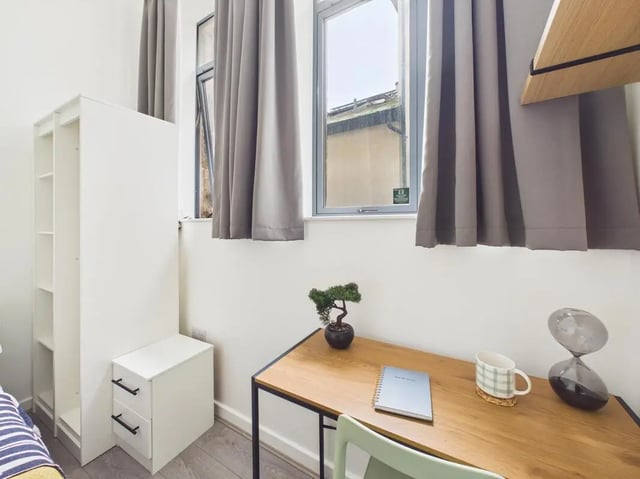Desk, shelf, hourglass, notebook, and plant study area at 3 Bedroom House at Flat 3, 18, China Street in Lancaster Student Accommodation