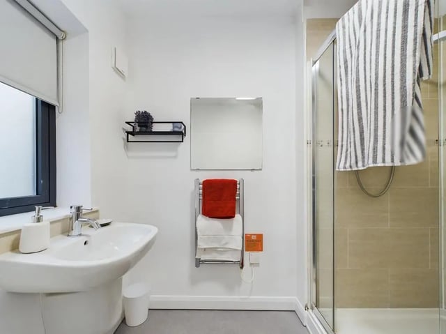 Sink towels shelf mirror and shower stall bathroom at 5 Bedroom House at Flat 4, 18, China Street in Lancaster Student Accommodation