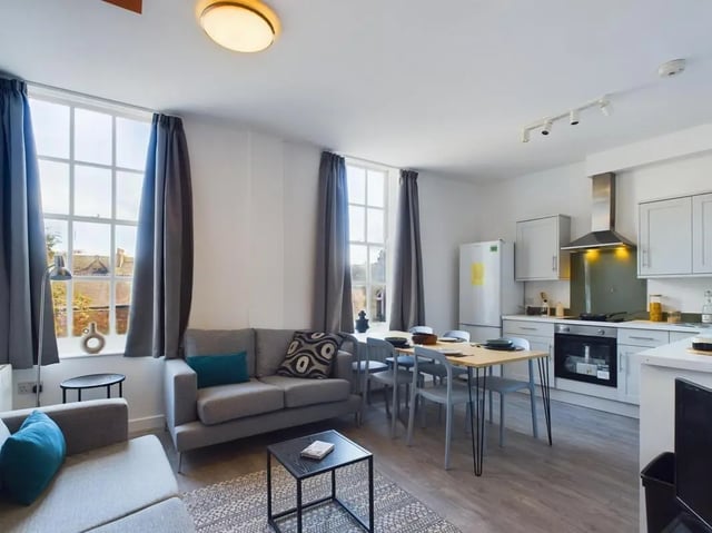 Sofa dining table kitchen appliances and windows open plan living area at 5 Bedroom House at Flat 4, 18, China Street in Lancaster Student Accommodation