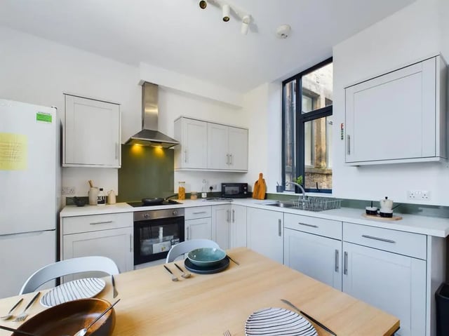 White kitchen with table fridge and cabinets kitchen at 5 Bedroom House at Flat 4, 18, China Street in Lancaster Student Accommodation