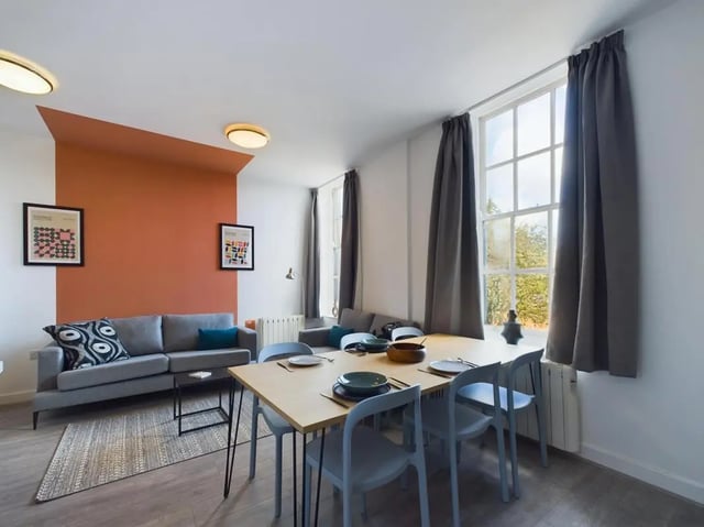Sofa dining table chairs and posters living room at 5 Bedroom House at Flat 4, 18, China Street in Lancaster Student Accommodation