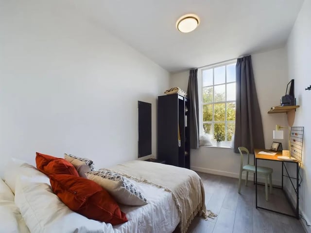 Bed with orange cushions wardrobe and desk Bedroom at 5 Bedroom House at Flat 4, 18, China Street in Lancaster Student Accommodation