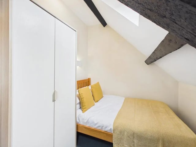 White wardrobe bed with yellow pillows and throw bedroom at 4 Bedroom House at Flat 9, 18, China Street in Lancaster Student Accommodation