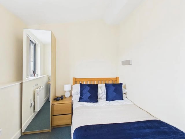 Bed with blue pillows bedside table mirror bedroom at 4 Bedroom House at Flat 9, 18, China Street in Lancaster Student Accommodation