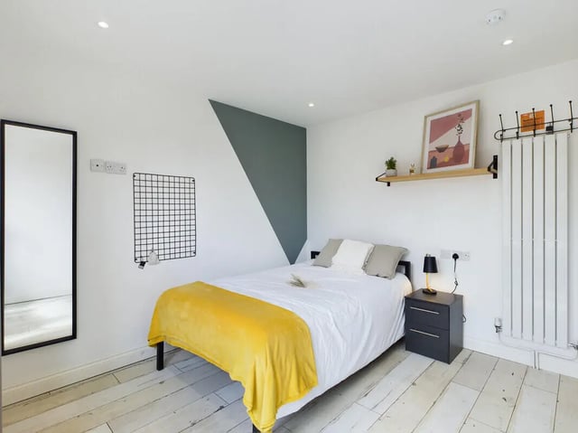Bed with yellow blanket side table mirror bedroom at 7 Bedroom House at 132, Uttoxeter New Road in Derby Student Accommodation