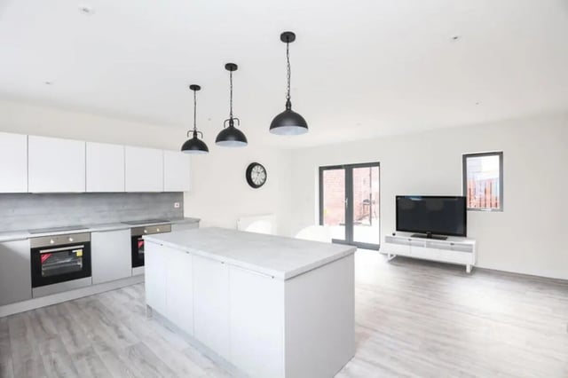 Modern kitchen with island and living area. at 7 Bedroom House at 6, Well Meadow Drive in Sheffield Student Accommodation