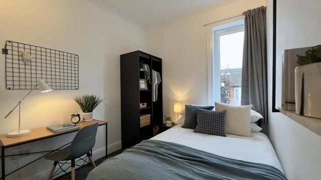 Desk plant clock wardrobe bed pillows bedroom at 6 Bedroom House at 214, West Parade in Lincoln Student Accommodation