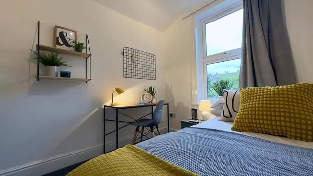Desk plants and bed with pillows bedroom at 6 Bedroom House at 214, West Parade in Lincoln Student Accommodation