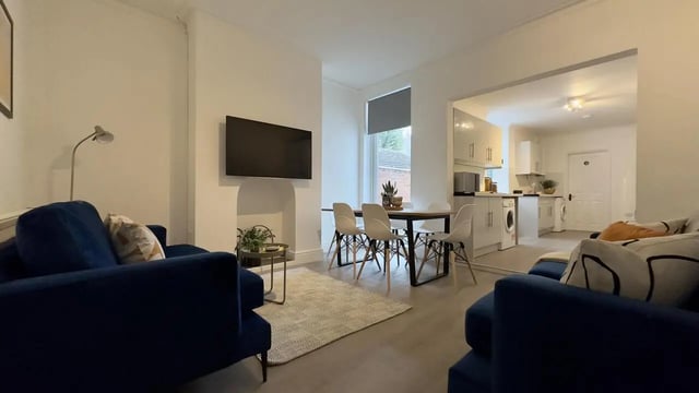 Blue sofas dining table kitchen living room at 6 Bedroom House at 214, West Parade in Lincoln Student Accommodation