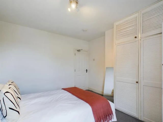 Bed with orange throw and large wardrobe Bedroom at 4 Bedroom House at 11, Charles Street West in Lincoln Student Accommodation