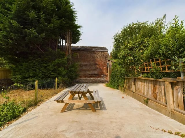 Wooden picnic table in a concrete yard exterior at 4 Bedroom House at 11, Charles Street West in Lincoln Student Accommodation