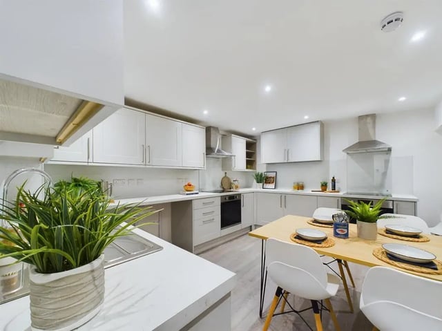Modern kitchen with dining table and white chairs kitchen at 8 Bedroom House at 69, Monks Road in Lincoln Student Accommodation
