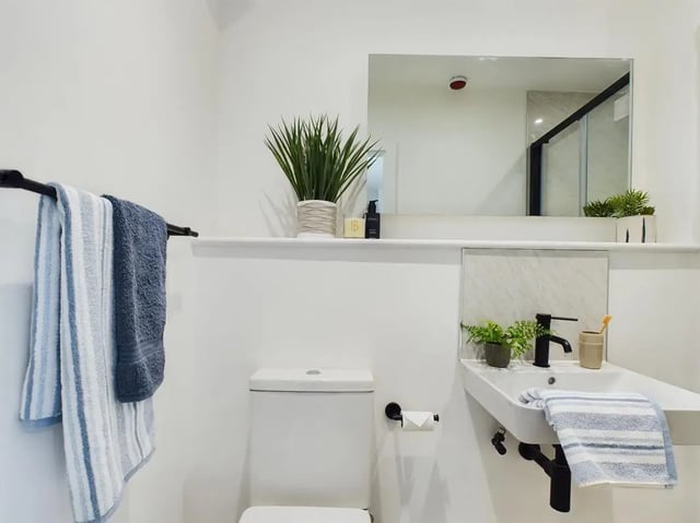 Toilet sink towels plant and mirror bathroom at 8 Bedroom House at 69, Monks Road in Lincoln Student Accommodation