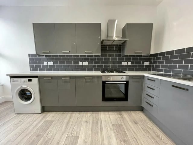 Grey cabinets oven washer tiled backsplash kitchen at 2 Bedroom House at 20 A, Portland Street in Lincoln Student Accommodation