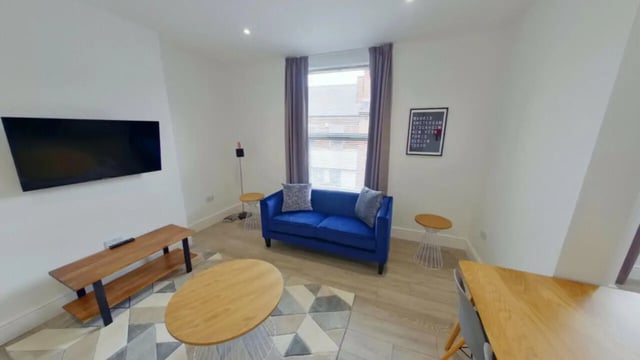 Blue sofa TV wooden table rug living room at 2 Bedroom House at 20 A, Portland Street in Lincoln Student Accommodation