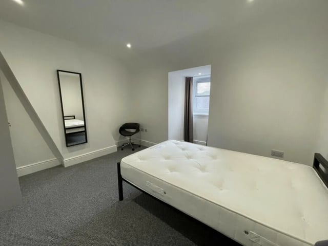 Bed mirror chair window bedroom at 2 Bedroom House at 20 A, Portland Street in Lincoln Student Accommodation