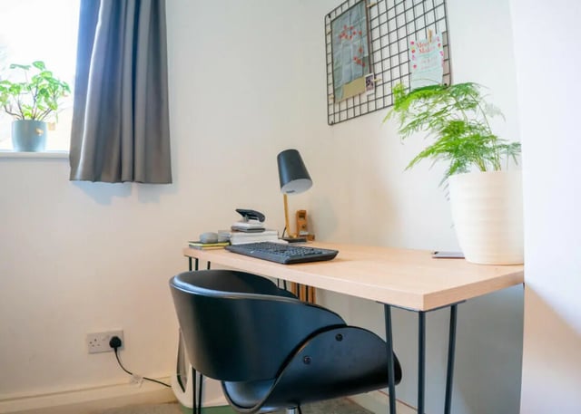 Desk with keyboard lamp chair and plants study area at 4 Bedroom House at 16, Kelsey Street in Lancaster Student Accommodation