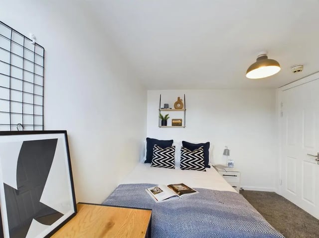 Bed with navy pillows and artwork bedroom at 7 Bedroom House at 6, KIPPAX STREET in Manchester Student Accommodation