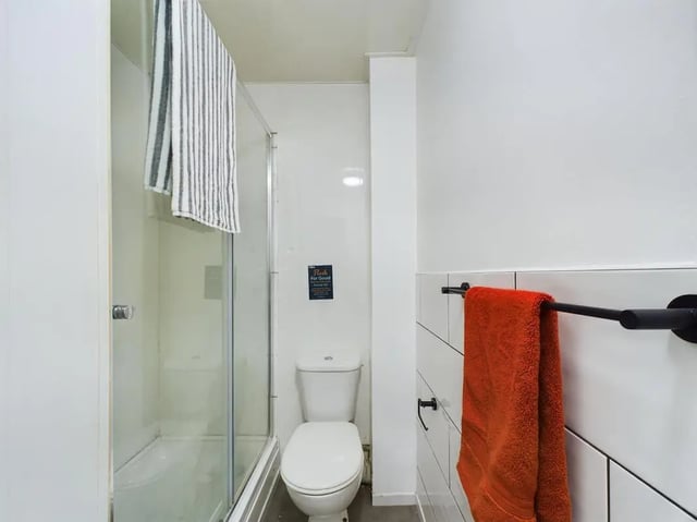 Shower stall toilet striped and orange towels bathroom at 7 Bedroom House at 6, KIPPAX STREET in Manchester Student Accommodation
