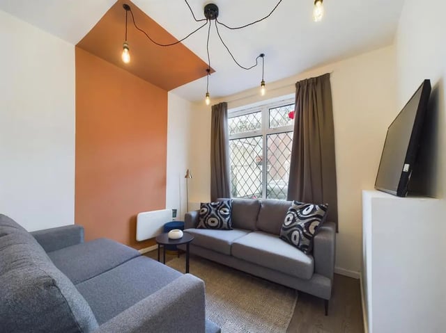Gray sofa patterned cushions modern lamps living room at 7 Bedroom House at 6, KIPPAX STREET in Manchester Student Accommodation