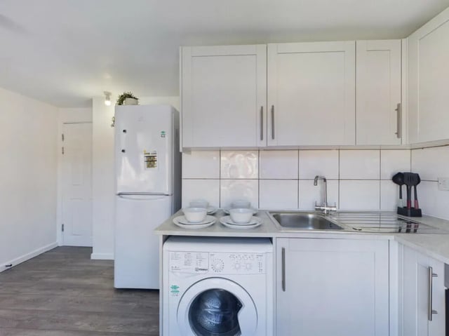 White kitchen with fridge washing machine and sink kitchen at 4 Bedroom House at Flat 1 30, Haydn Avenue in Manchester Student Accommodation