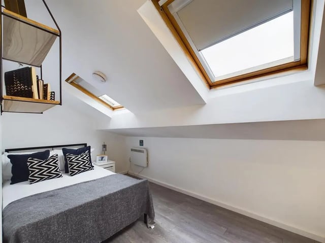 Bed with pillows, shelves, and skylights Bedroom at 4 Bedroom House at Flat 1, 58, Ruskin Avenue in Manchester Student Accommodation