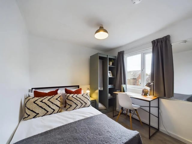 Bed with patterned pillows wardrobe and desk Bedroom at 4 Bedroom House at Flat 1, 58, Ruskin Avenue in Manchester Student Accommodation
