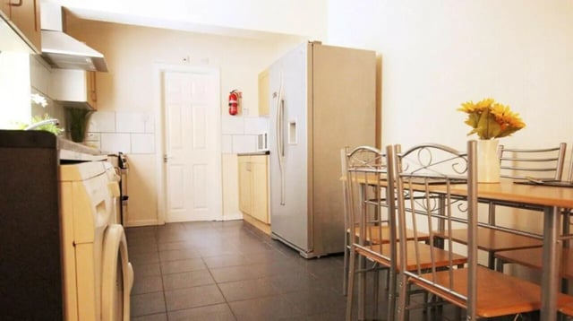 Fridge washing machine dining table kitchen at 6 Bedroom House at 5, ASHFIELD ROAD in Manchester Student Accommodation