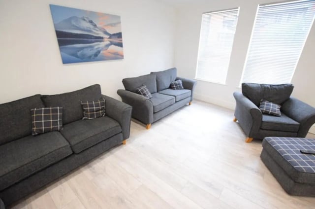 Two grey sofas and armchairs living room at 10 Bedroom House at 15, Monks Road in Lincoln Student Accommodation