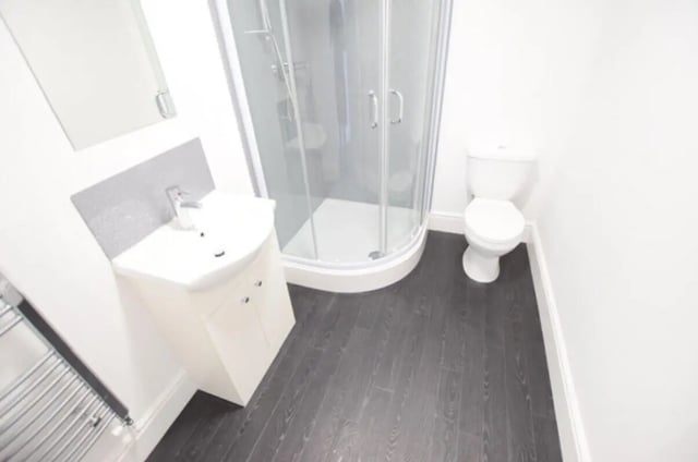Sink shower and toilet with dark floor bathroom at 10 Bedroom House at 15, Monks Road in Lincoln Student Accommodation
