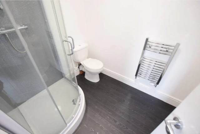 Shower toilet towel rack and dark floor bathroom at 10 Bedroom House at 15, Monks Road in Lincoln Student Accommodation