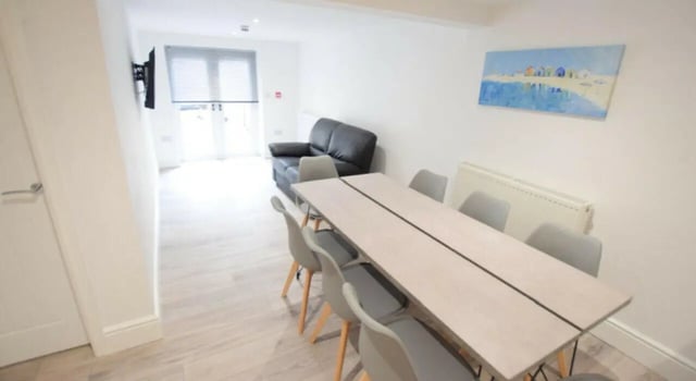 Dining table and sofa in living area at 10 Bedroom House at 15, Monks Road in Lincoln Student Accommodation