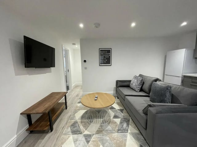 Grey sectional couch coffee table TV living room at 2 Bedroom House at 20 E, Portland Street in Lincoln Student Accommodation