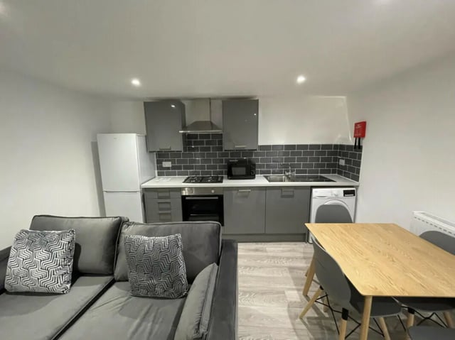 Sofa fridge oven washing machine table kitchen living room at 2 Bedroom House at 20 E, Portland Street in Lincoln Student Accommodation