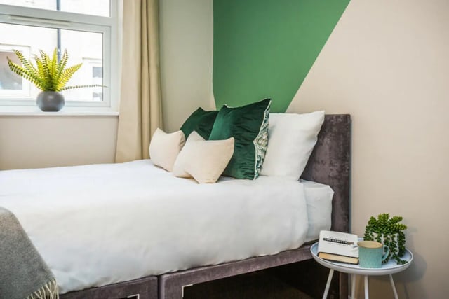 Bed with pillows plants and book bedroom at 5 Bedroom House at 64, Monson Street in Lincoln Student Accommodation