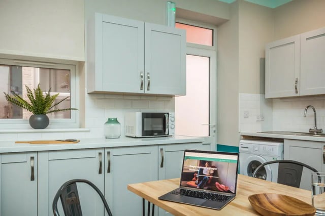 Laptop plant microwave and cabinets kitchen at 5 Bedroom House at 64, Monson Street in Lincoln Student Accommodation